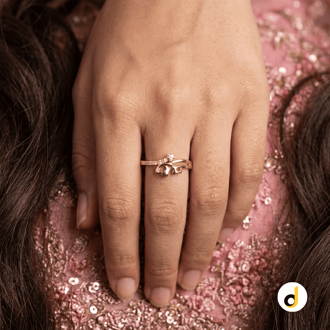 Close-up of a finger wearing a gold wave ring with clear stone details Close-up of a finger wearing a gold wave ring with clear stone details
